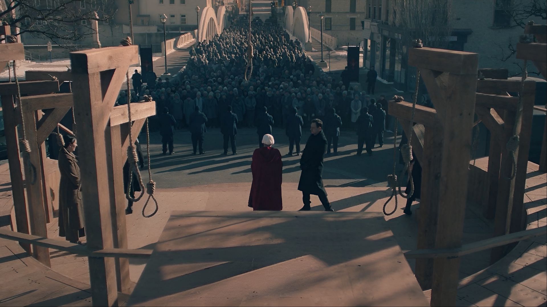 June stands before a mass execution platform in The Handmaid's Tale season 6 episode 9, as the crowd gathers and hope dwindles (Image via Hulu)